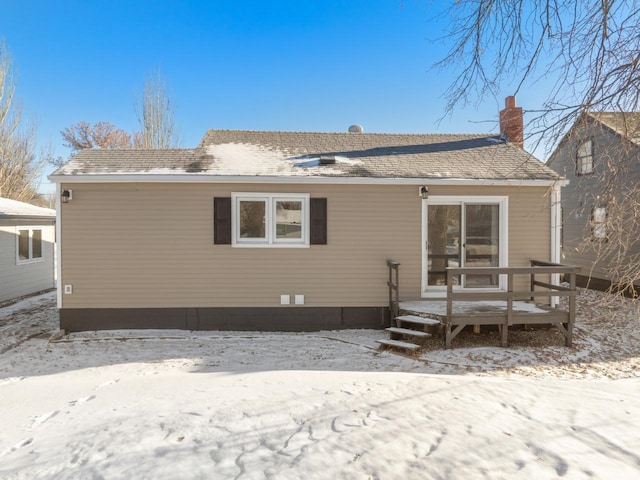 view of snow covered back of property