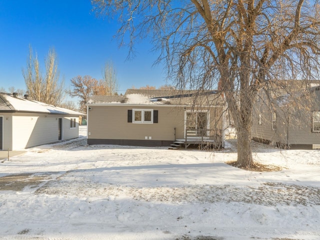 view of snow covered back of property