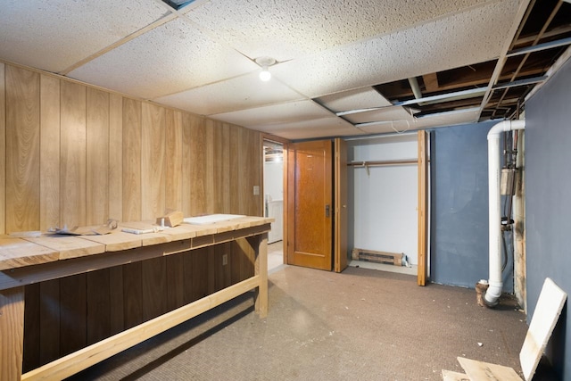 unfurnished bedroom featuring washer / clothes dryer, a closet, and wood walls