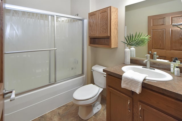 full bathroom featuring vanity, enclosed tub / shower combo, and toilet