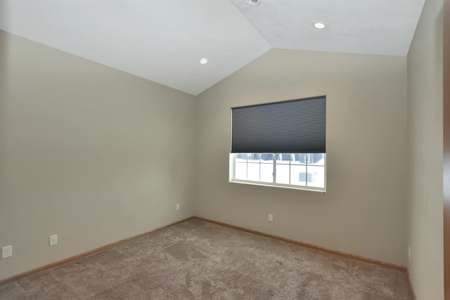 spare room with light colored carpet and lofted ceiling