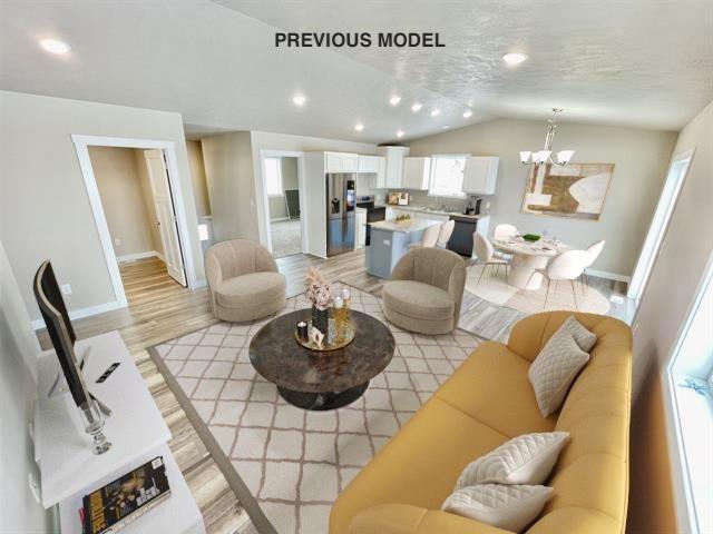 living room with a chandelier, light hardwood / wood-style flooring, and lofted ceiling