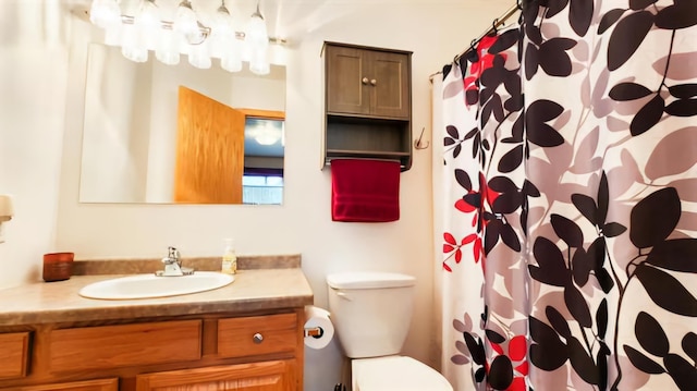 bathroom with a shower with shower curtain, vanity, and toilet