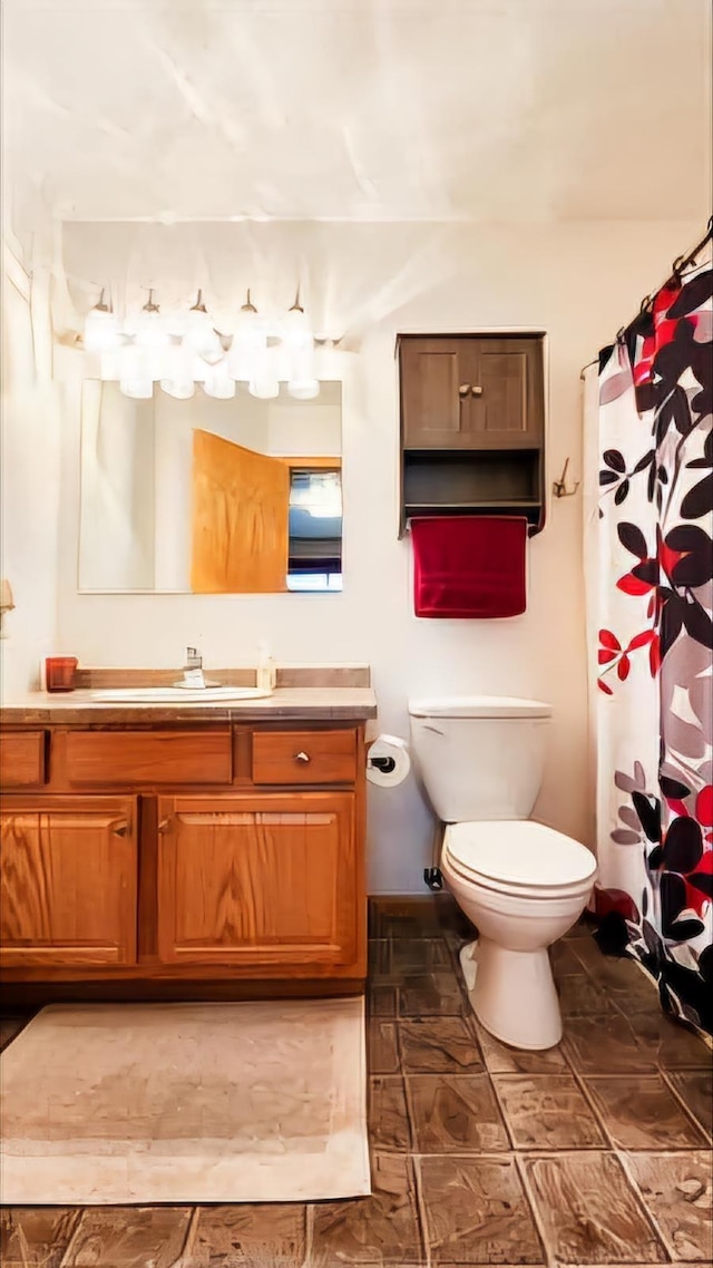 bathroom featuring walk in shower, vanity, and toilet