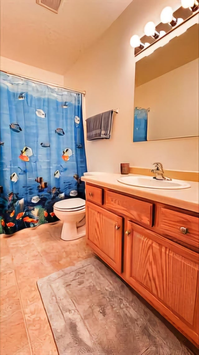 bathroom featuring vanity, toilet, and walk in shower