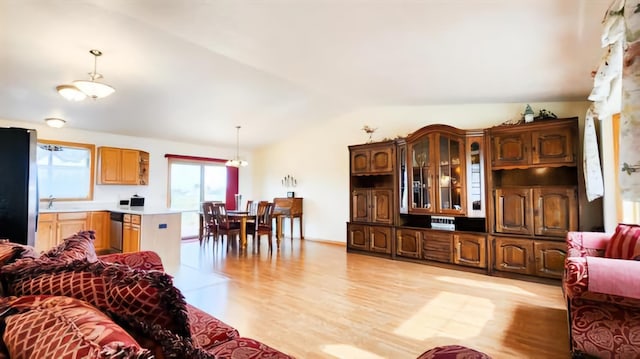 living room featuring sink, light hardwood / wood-style floors, and vaulted ceiling