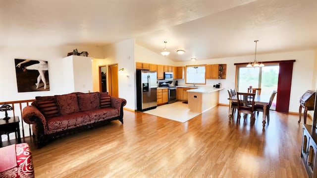 living room featuring a chandelier, light hardwood / wood-style flooring, and vaulted ceiling