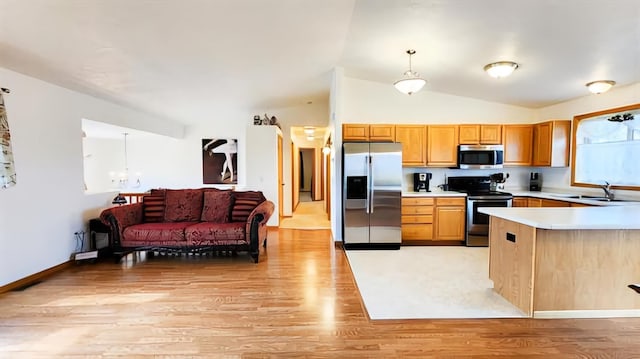 kitchen featuring appliances with stainless steel finishes, light wood-type flooring, vaulted ceiling, and hanging light fixtures