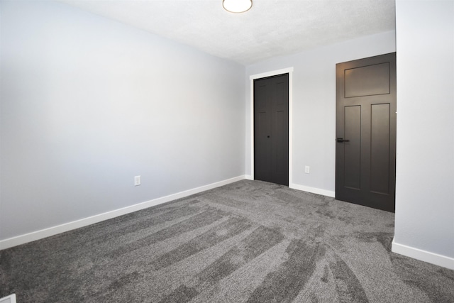 unfurnished bedroom with dark carpet