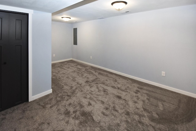 unfurnished room with electric panel and dark colored carpet