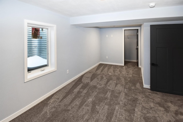 spare room with dark colored carpet