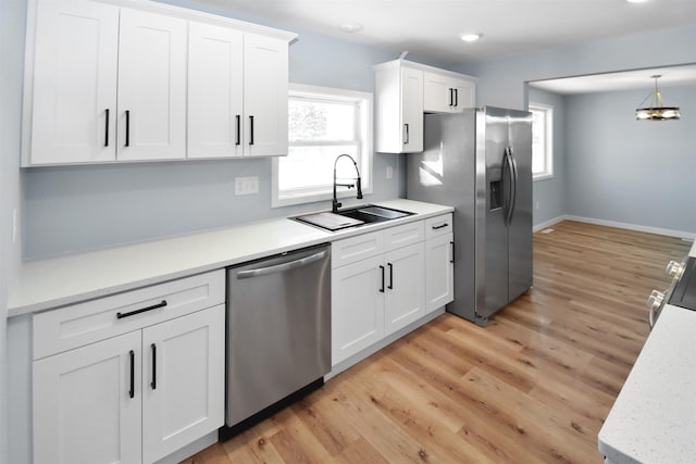 kitchen featuring a wealth of natural light, sink, white cabinets, and appliances with stainless steel finishes