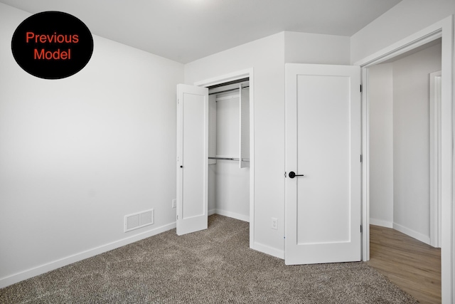 unfurnished bedroom with light carpet and a closet