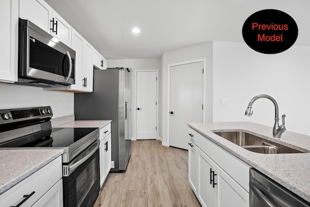 kitchen featuring light stone countertops, sink, white cabinets, and appliances with stainless steel finishes