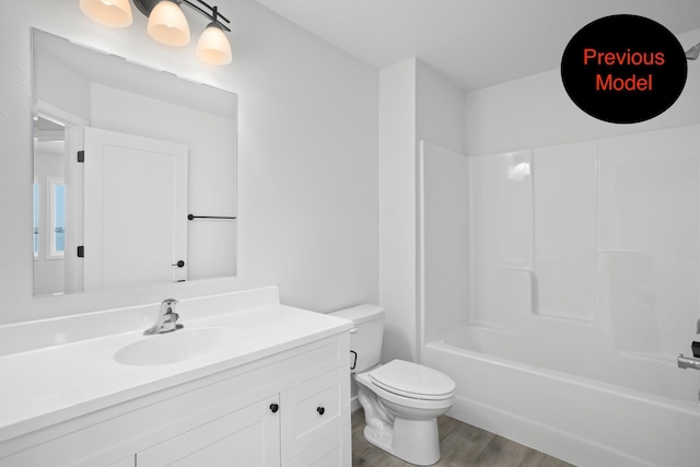 full bathroom featuring vanity, washtub / shower combination, wood-type flooring, and toilet