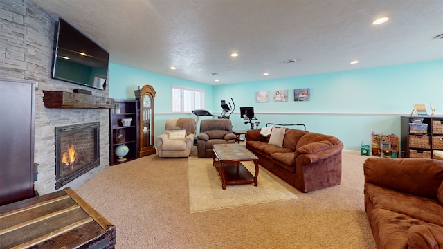 carpeted living room featuring a stone fireplace and a textured ceiling