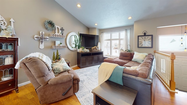 living room featuring light hardwood / wood-style floors and vaulted ceiling