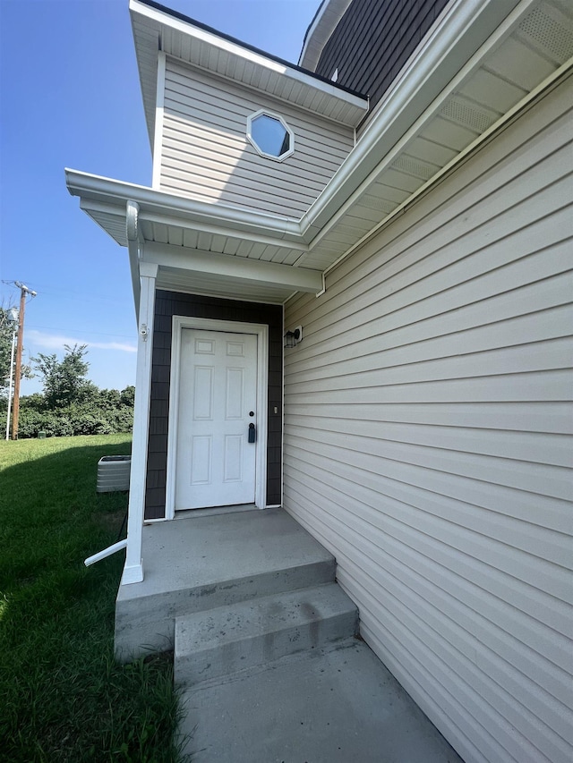 entrance to property featuring a lawn