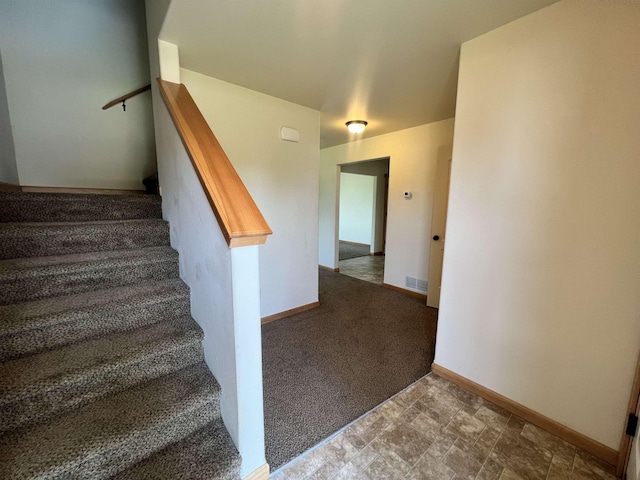 staircase featuring carpet flooring