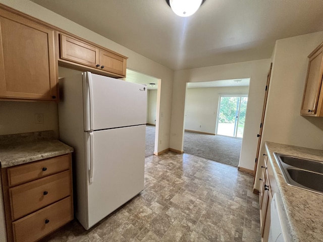 kitchen with dishwasher, white refrigerator, sink, light brown cabinetry, and light colored carpet