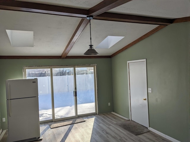 unfurnished room featuring light hardwood / wood-style floors and lofted ceiling with skylight