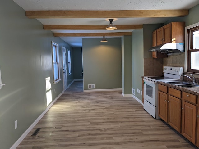 kitchen featuring beam ceiling, electric range, sink, and light hardwood / wood-style floors