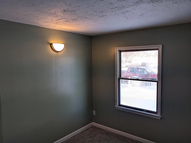 carpeted empty room featuring a textured ceiling