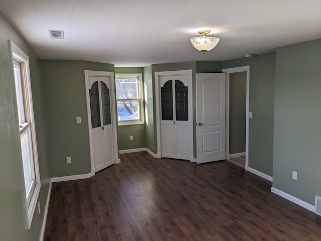 foyer entrance with dark hardwood / wood-style flooring and a textured ceiling