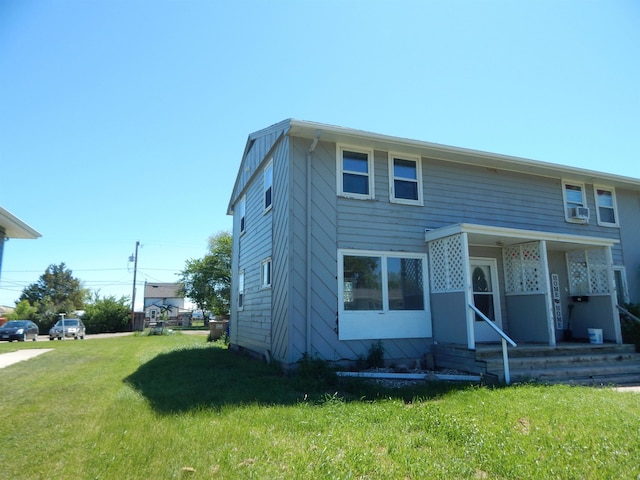 view of front of home featuring cooling unit and a front yard