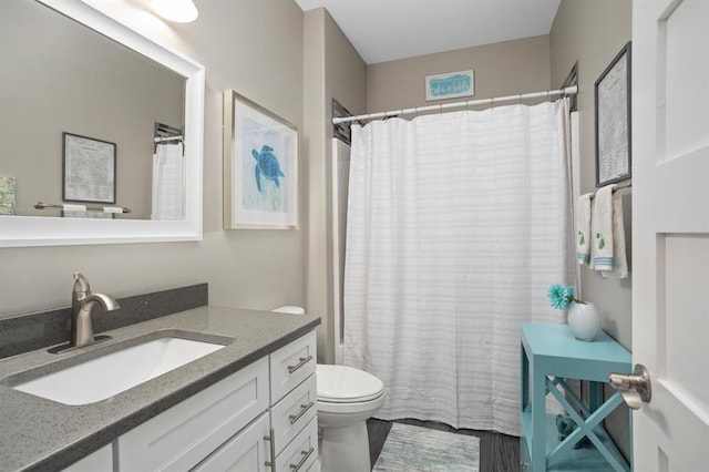 bathroom featuring a shower with shower curtain, vanity, and toilet