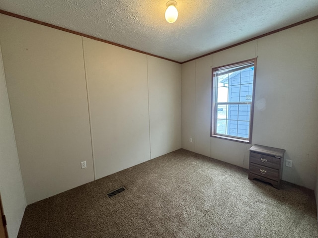 carpeted empty room with a textured ceiling