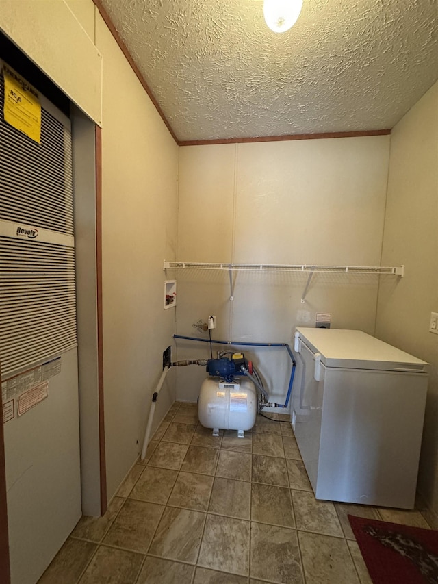 clothes washing area with a textured ceiling and hookup for a washing machine