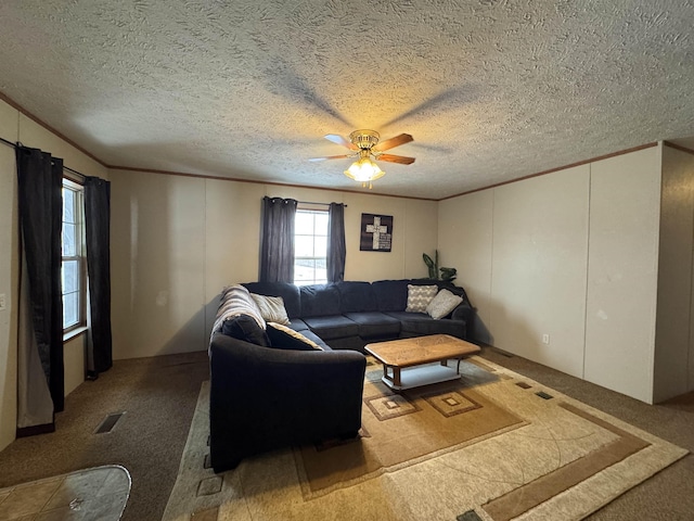 carpeted living room featuring a textured ceiling, ceiling fan, and ornamental molding