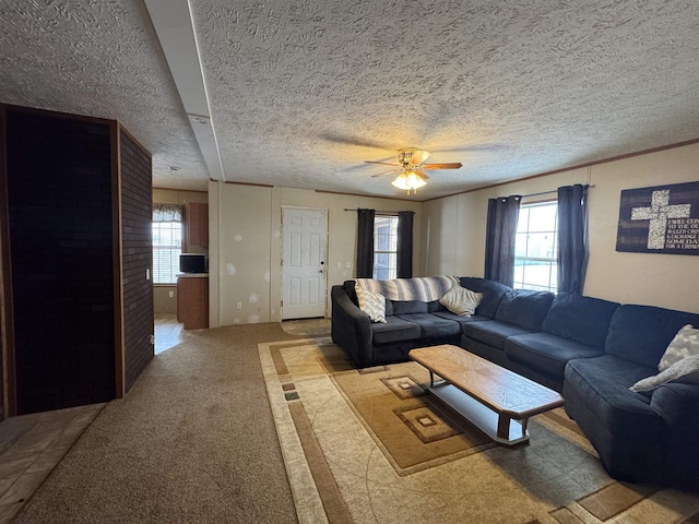 living room with ceiling fan, light colored carpet, a textured ceiling, and a wealth of natural light