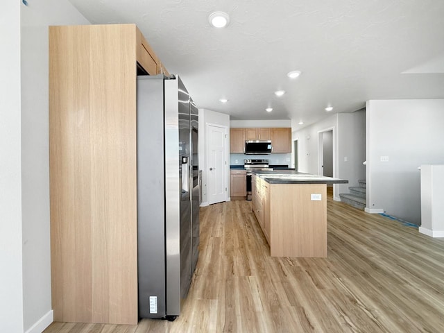 kitchen featuring a center island, light hardwood / wood-style floors, stainless steel appliances, and light brown cabinets