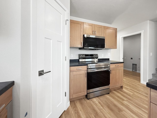 kitchen with appliances with stainless steel finishes and light hardwood / wood-style floors