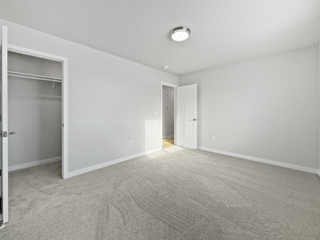 unfurnished bedroom featuring light colored carpet and a closet