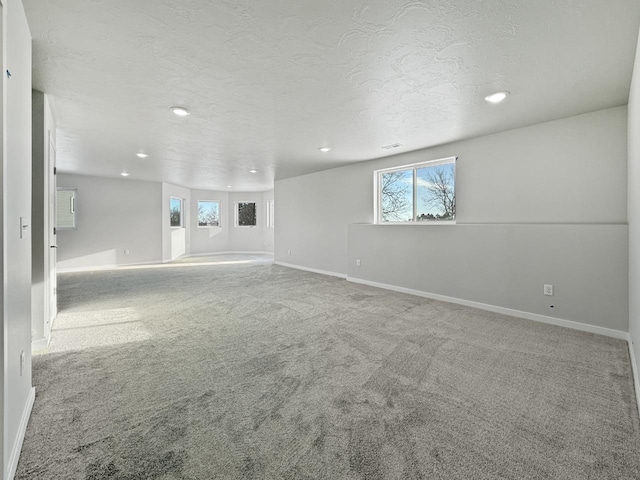 carpeted spare room with a textured ceiling