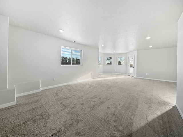 carpeted spare room featuring a textured ceiling