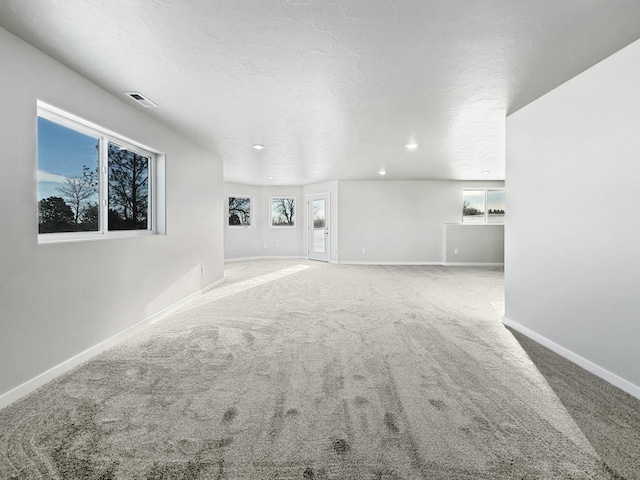 unfurnished living room with carpet floors and a textured ceiling