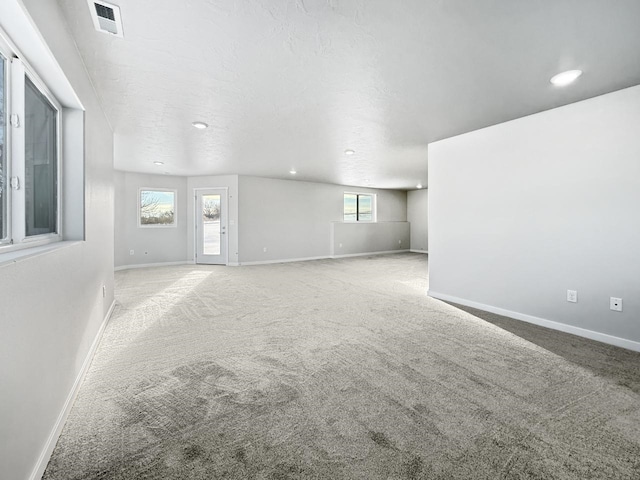 interior space featuring carpet flooring and a textured ceiling