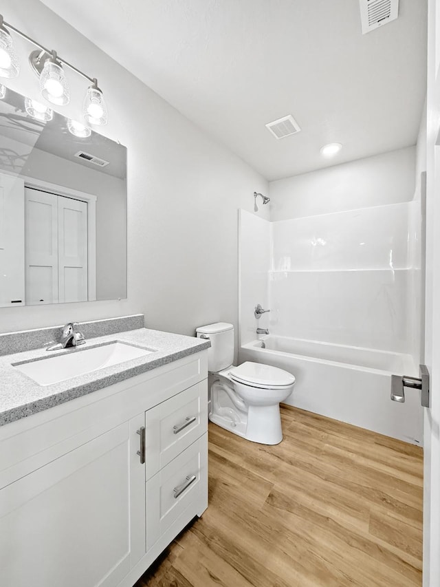 full bathroom featuring bathing tub / shower combination, vanity, wood-type flooring, and toilet