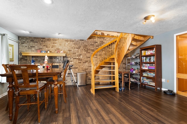 dining area featuring a textured ceiling, brick wall, and dark hardwood / wood-style floors