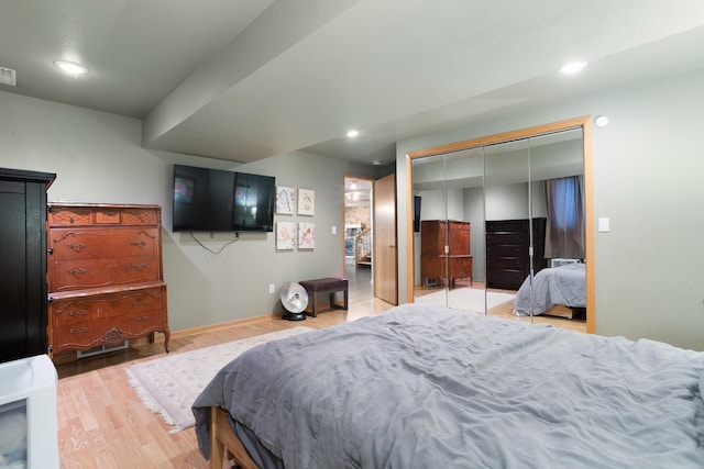 bedroom with light hardwood / wood-style floors and a closet