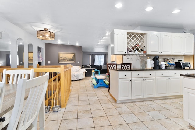 kitchen featuring white cabinets, light tile patterned floors, and tasteful backsplash