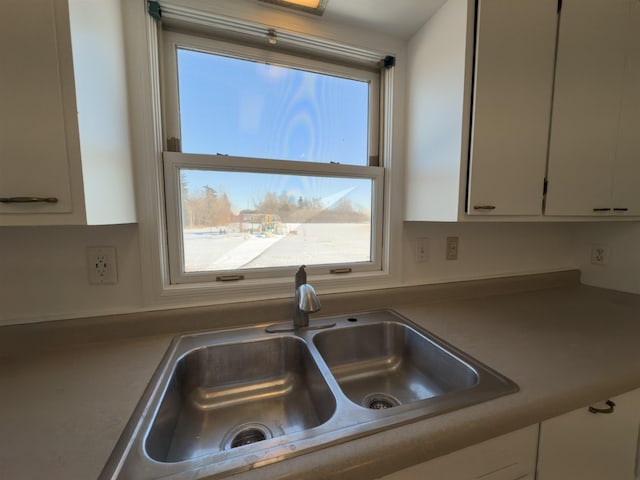 kitchen featuring white cabinetry and sink