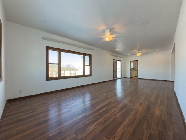 empty room with ceiling fan and dark hardwood / wood-style flooring