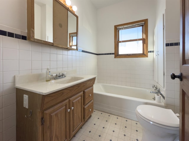 bathroom with a tub, vanity, tile walls, and toilet