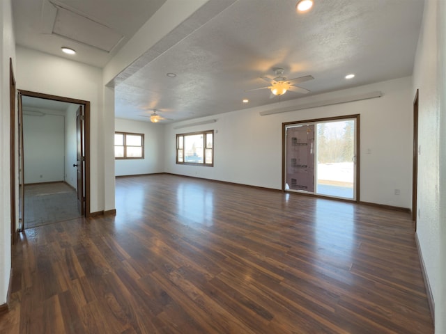 unfurnished living room with ceiling fan, dark wood-type flooring, and a textured ceiling