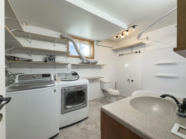 washroom featuring sink, track lighting, and independent washer and dryer